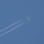 Flugzeug mit Kondenzstreifen geben den Wolkenlosen bleuen Himmel