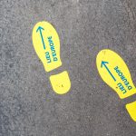 Gelbe Schuhabdrücke sind auf den Boden geklebt